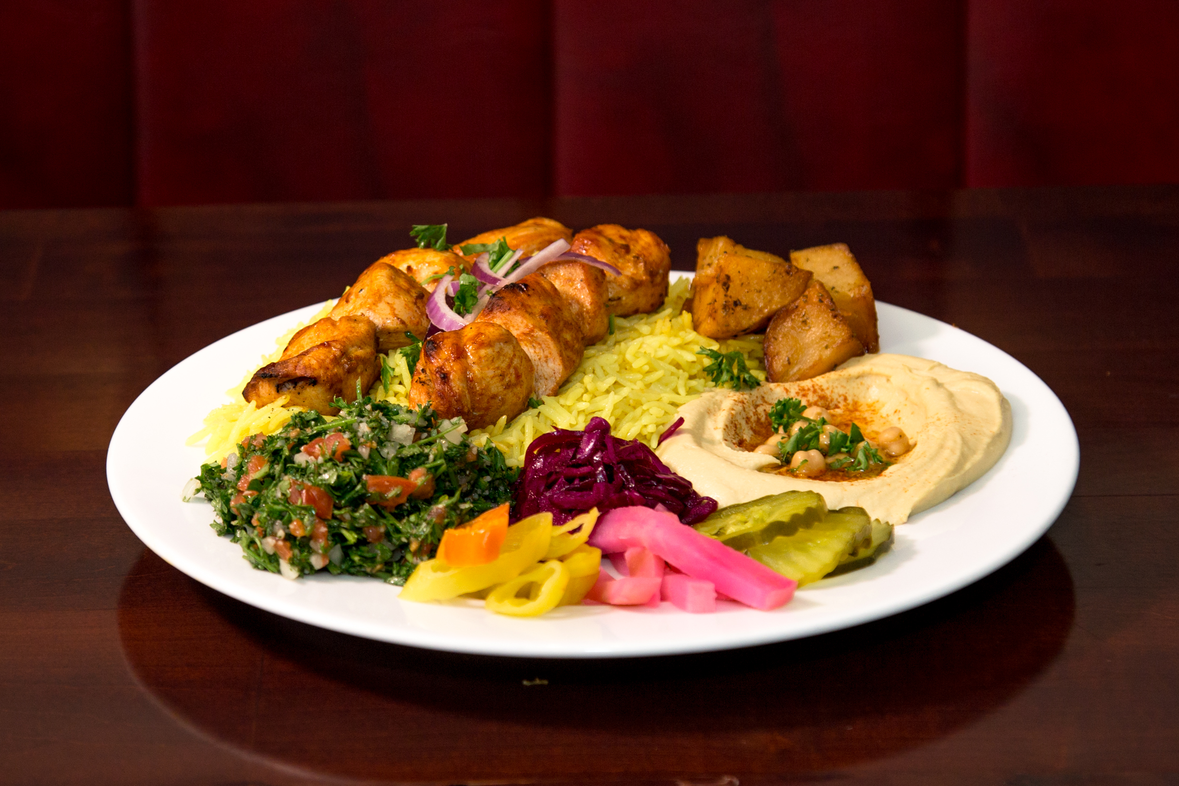 Tawouk platter comes with salad rice hummus and potatoes